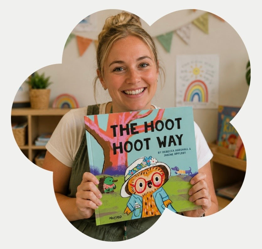 A smiling woman holds a children's book titledc